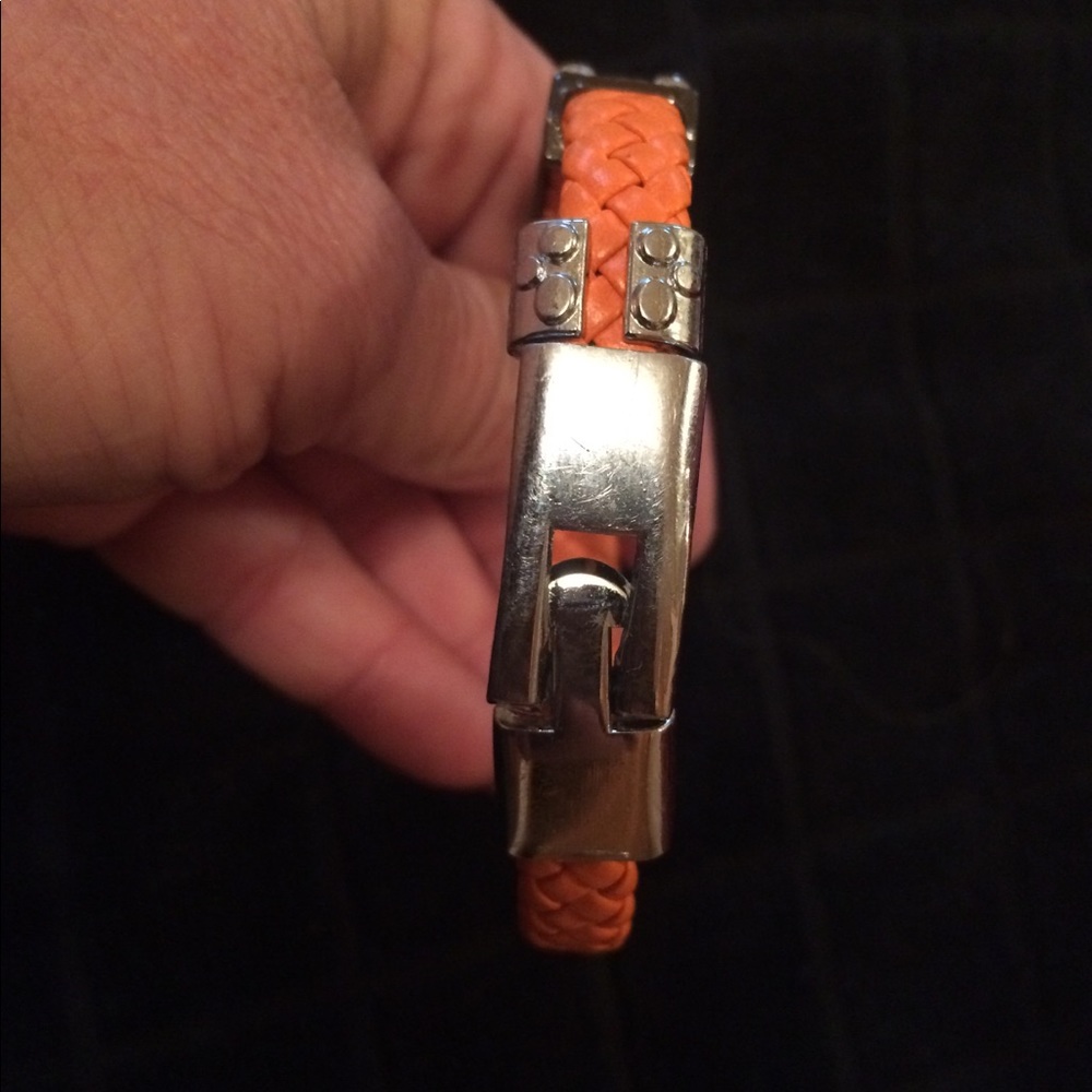 Orange bracelet with cross on it